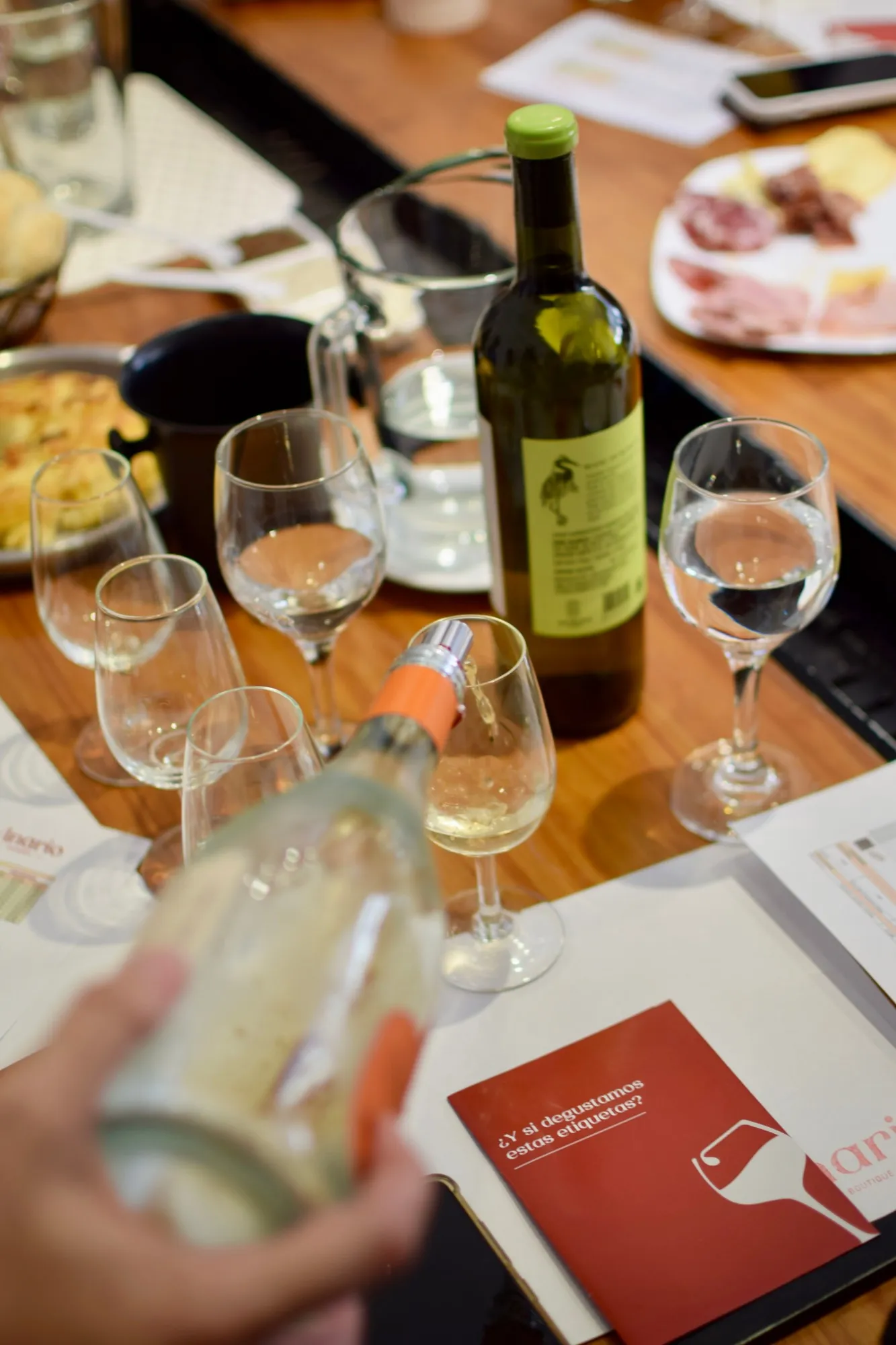 Copas, botellas y picada sobre la mesa de degustación
