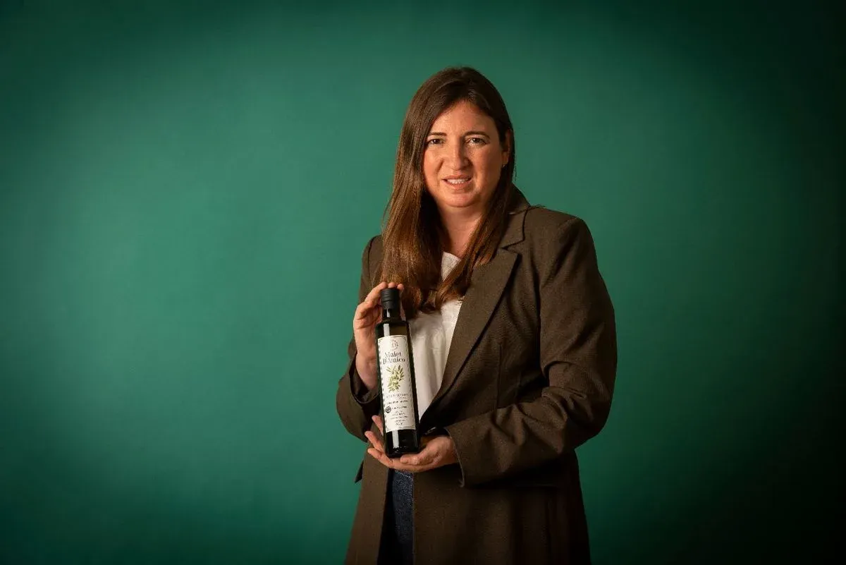 Botella de aceite de oliva virgen extra Mulet D'Amico sobre fondo verde